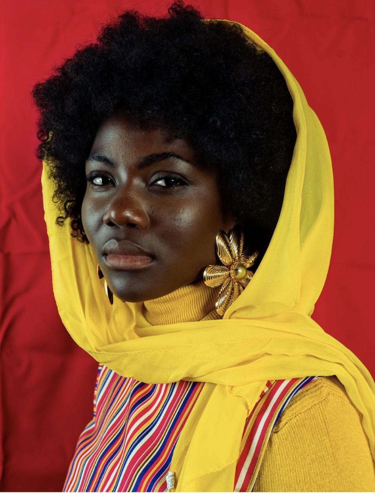 Yellow headscarf portrait against red backdrop